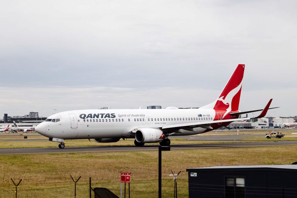 Qantas plane taxiing on runway.