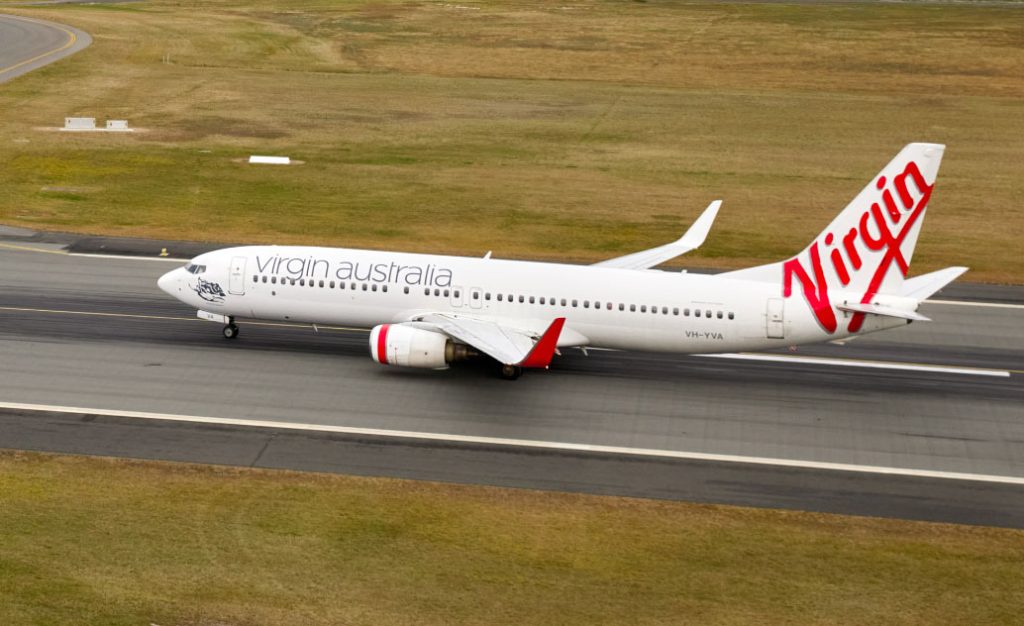 Virgin plane taxiing along runway.