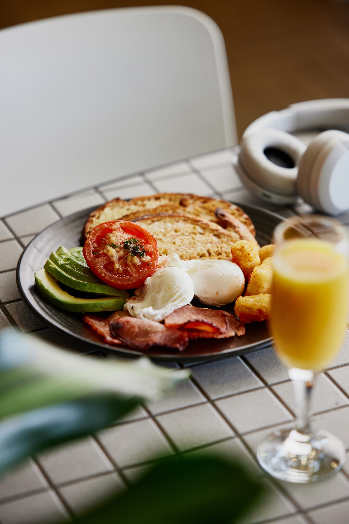 Cascade Classic Breakfast menu item on white and black tiled table with mimosa in foreground.