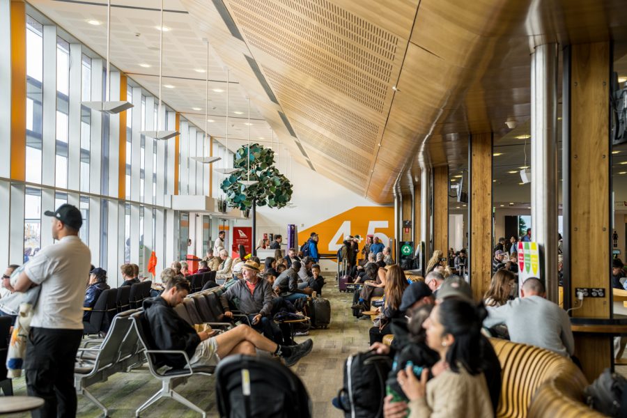 Departures lounge at Hobart Airport, busy with people.