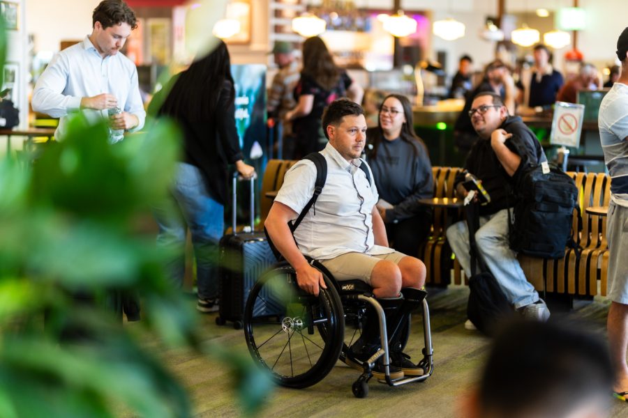 Man in wheelchair, queuing in line.