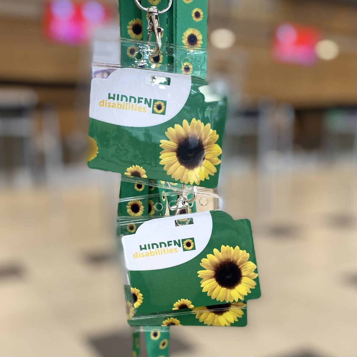 Green sunflower lanyards indicating invisible disability support.